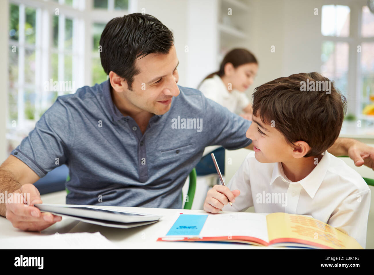 Father Helping Son With Homework Using Digital Tablet Stock Photo - Alamy