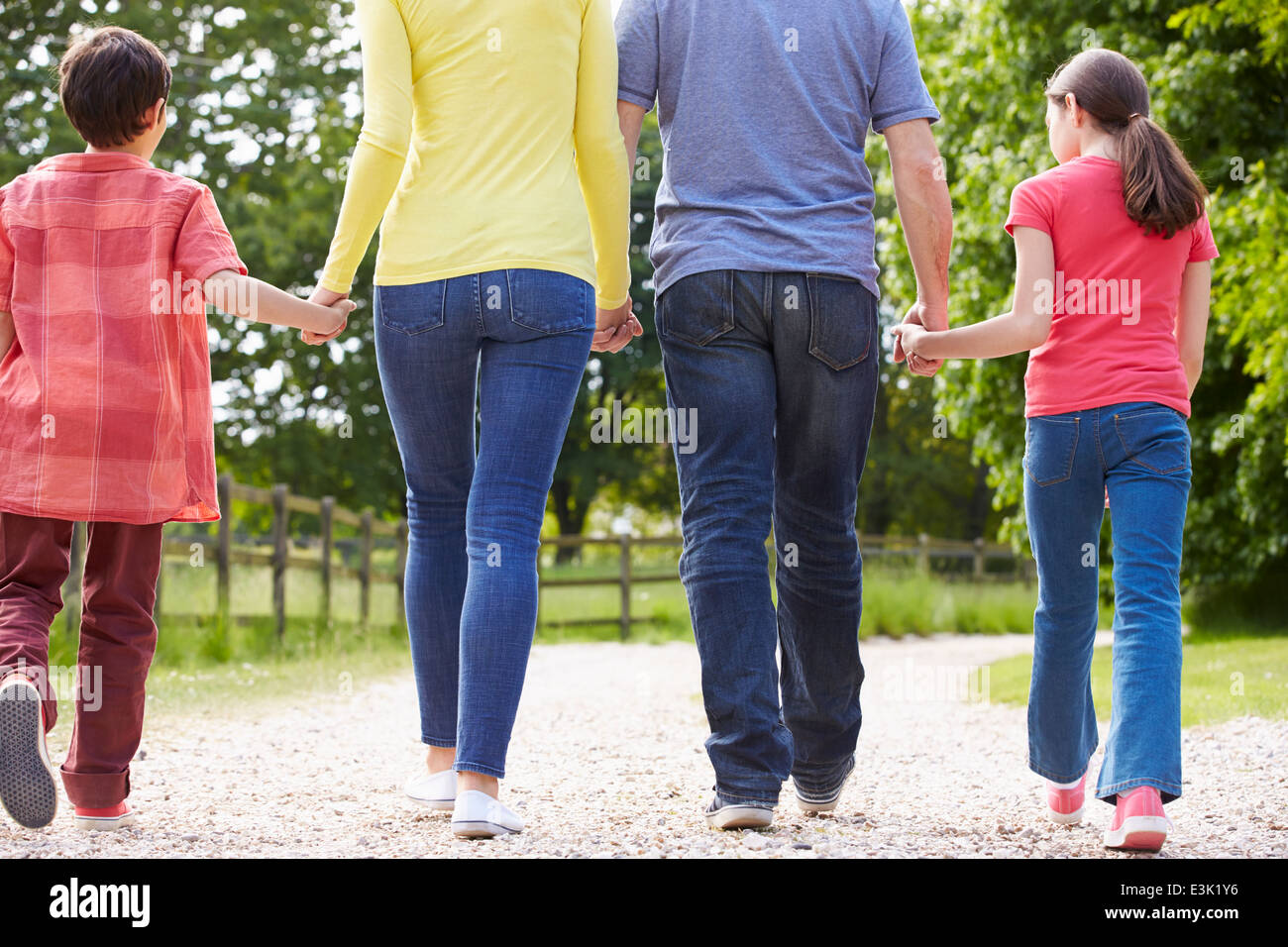 Rear View Of Hispanic Family Walking In Countryside Stock Photo