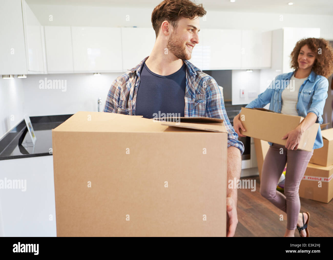 Couple Moving Into New Home And Unpacking Boxes Stock Photo - Alamy