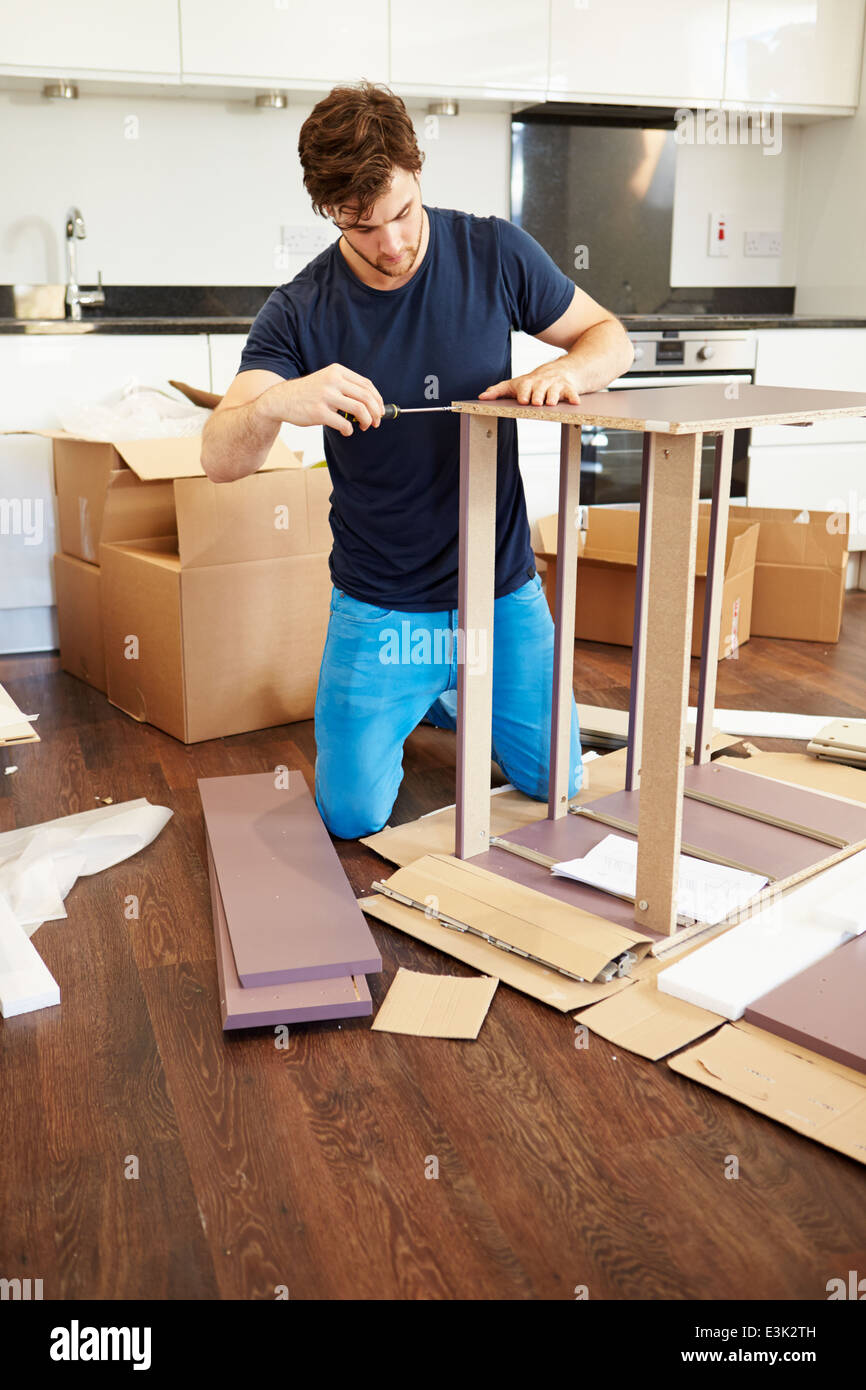 Man Putting Together Self Assembly Furniture In New Home Stock Photo