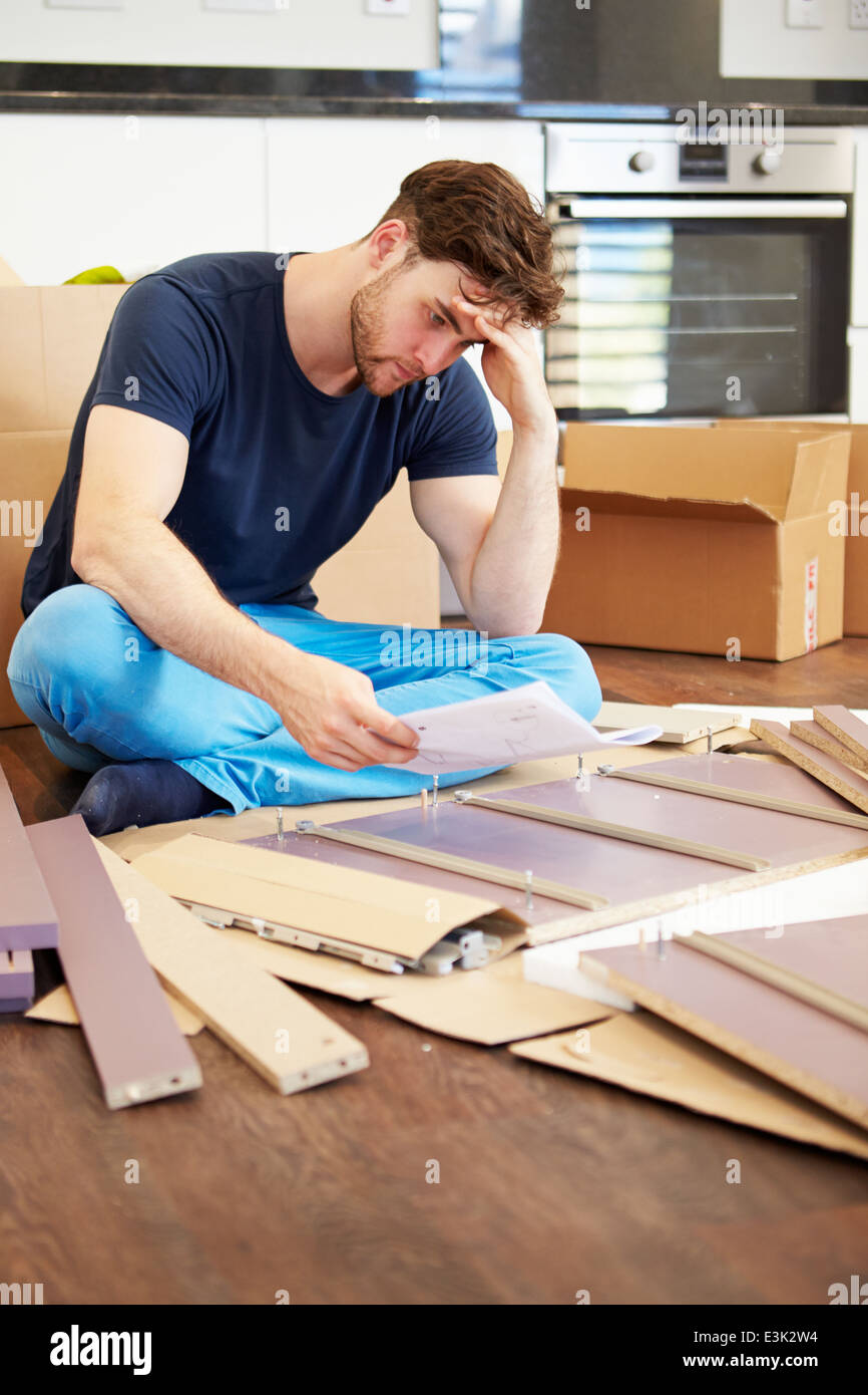 Frustrated Man Putting Together Self Assembly Furniture Stock Photo
