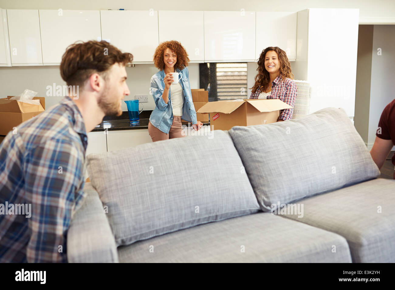 Men Carrying Sofa Helping With Move Into New Home Stock Photo