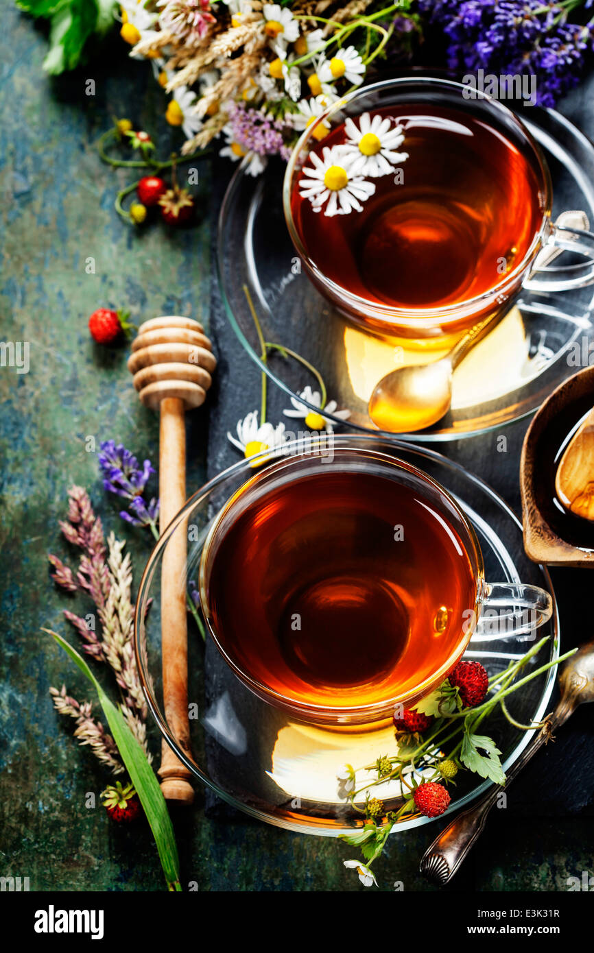Herbal tea with honey, wild berry and flowers on wooden background Stock Photo