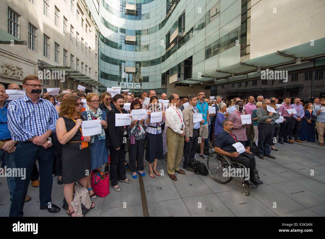 Portland Place, BBC Broadcasting House, London UK. 24th June 2014. Journalists and staff, many with mouths taped, meet outside BBC headquarters building to protest and hold a one minute silence in support of Al Jazeera journalists imprisoned in Egypt. #FreeAJStaff Credit:  Malcolm Park editorial/Alamy Live News. Stock Photo