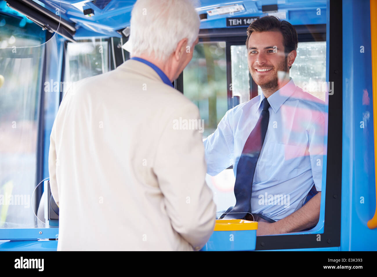 Senior Man Boarding Bus And Buying Ticket Stock Photo