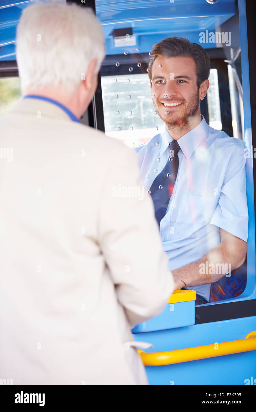 Senior Man Boarding Bus And Buying Ticket Stock Photo