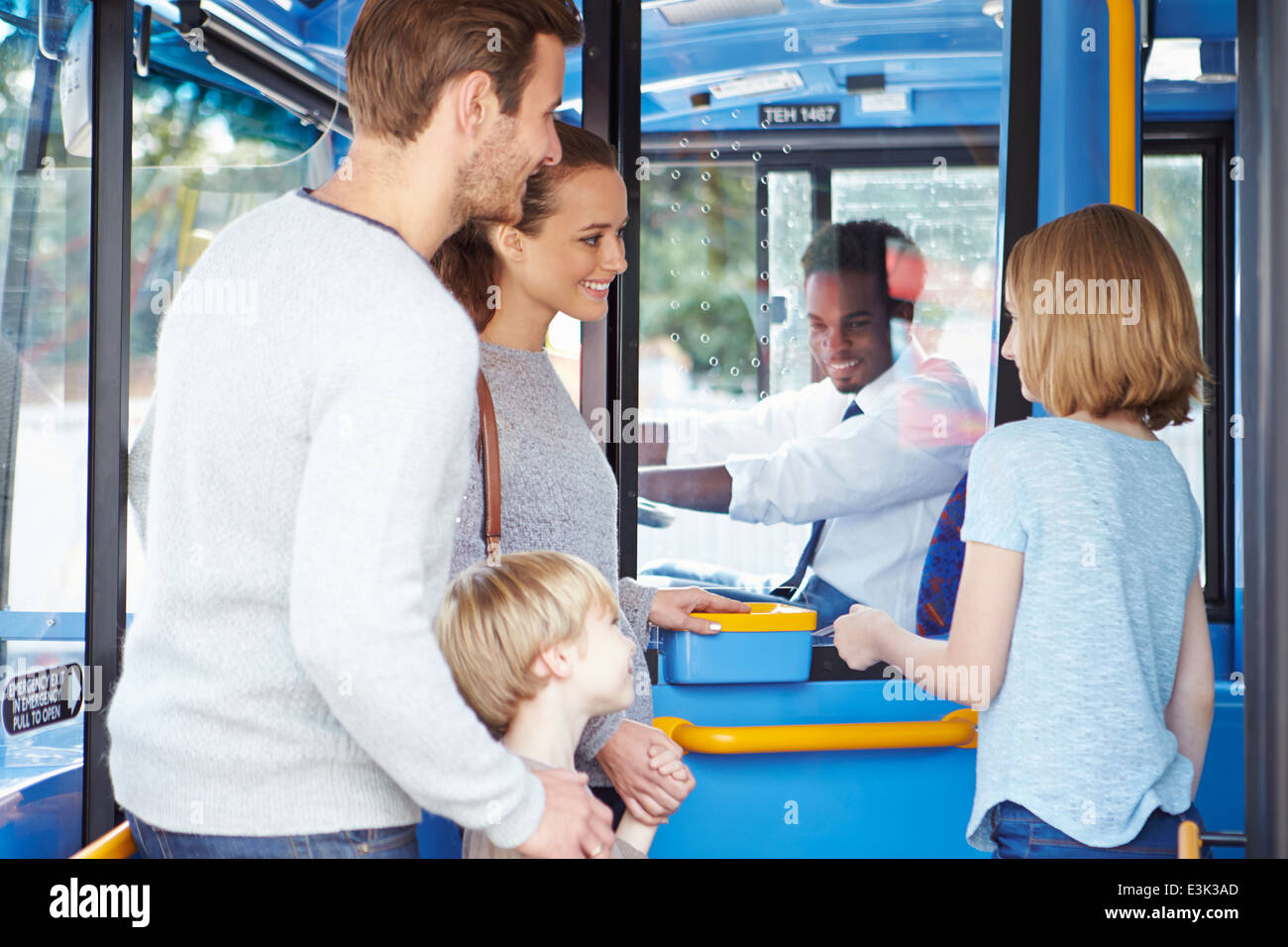 Family Boarding Bus And Buying Ticket Stock Photo