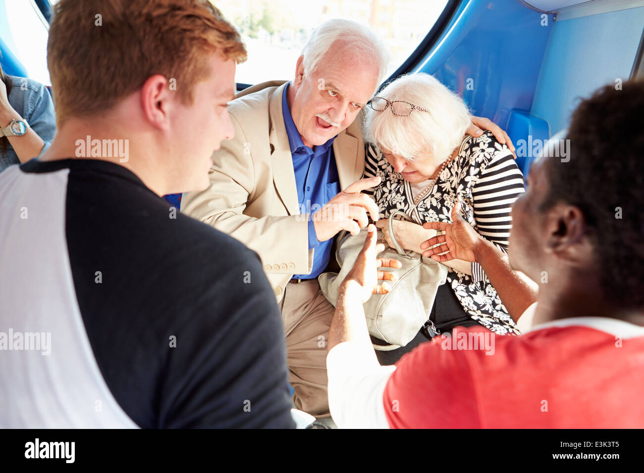 Senior Couple Being Harassed On Bus Journey Stock Photo
