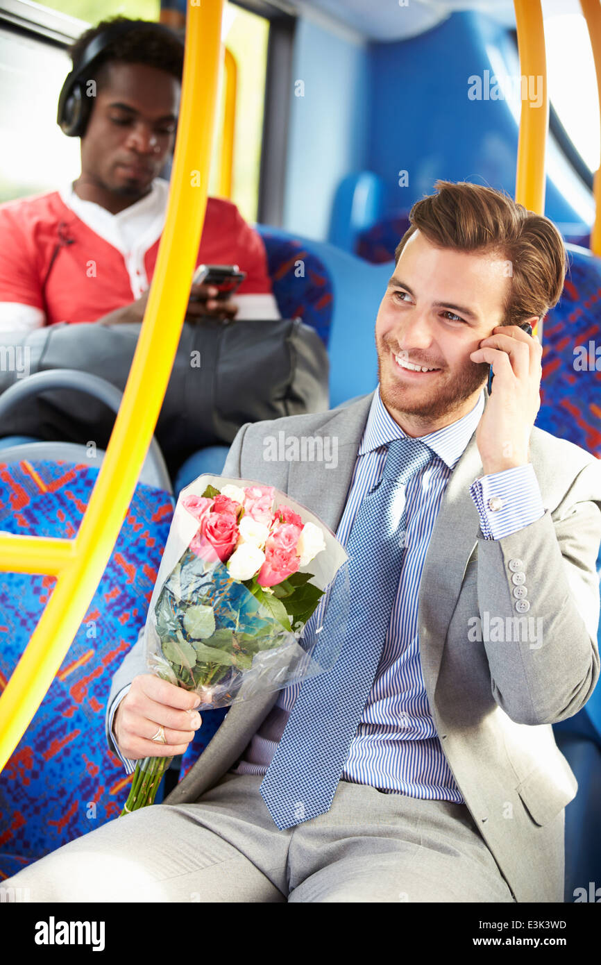 Man Going To Date On Bus Holding Bunch Of Flowers Stock Photo