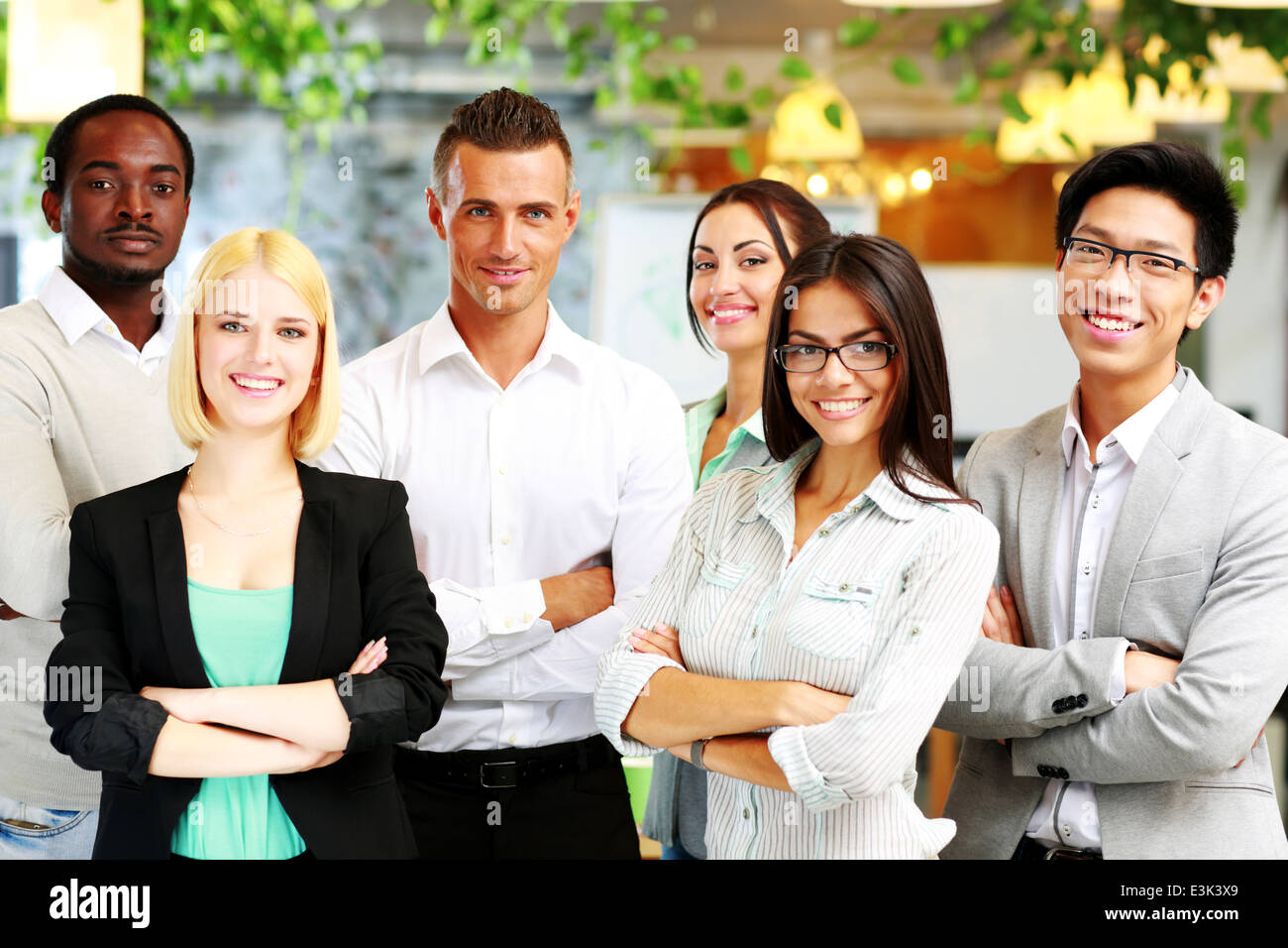 Group of a happy businesspeople standing together in office Stock Photo ...