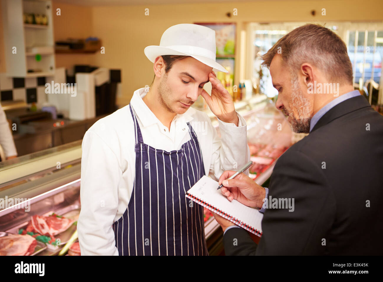 Bank Manager Meeting With Owner Of Butchers Shop Stock Photo