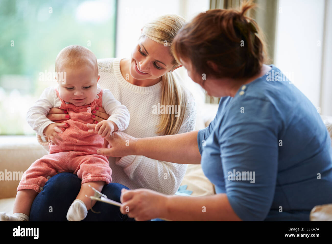 Health Visitor Talking To Mother With Young Baby Stock Photo