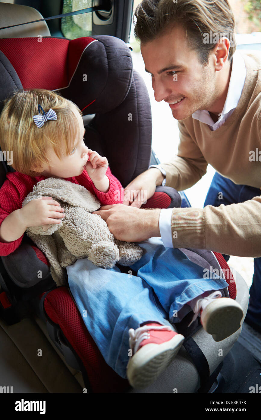 Father Putting Young Girl Into Car Seat Stock Photo Alamy