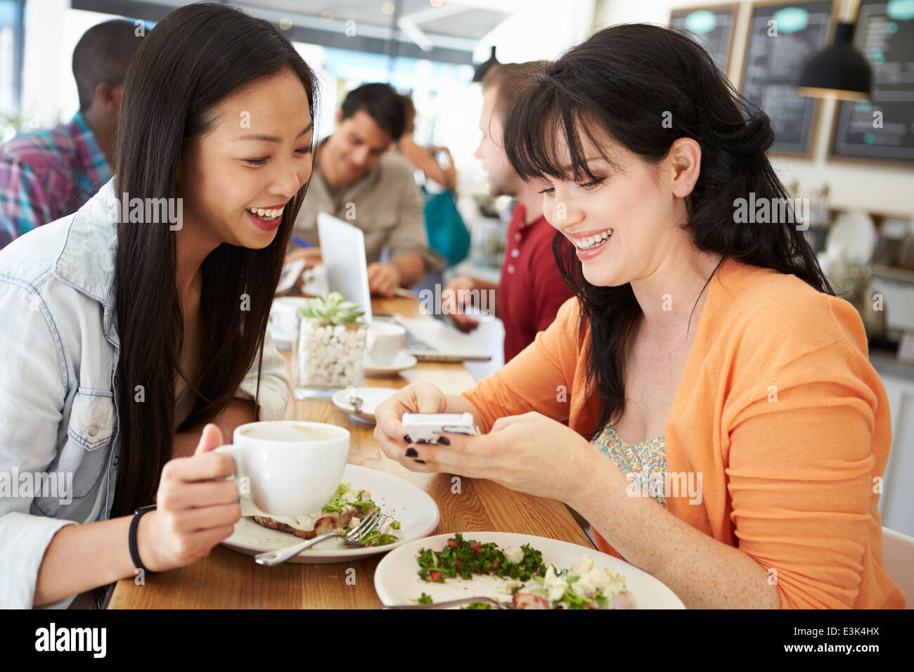 Two Female Friends Friends Meeting For Lunch In Coffee Shop Stock Photo