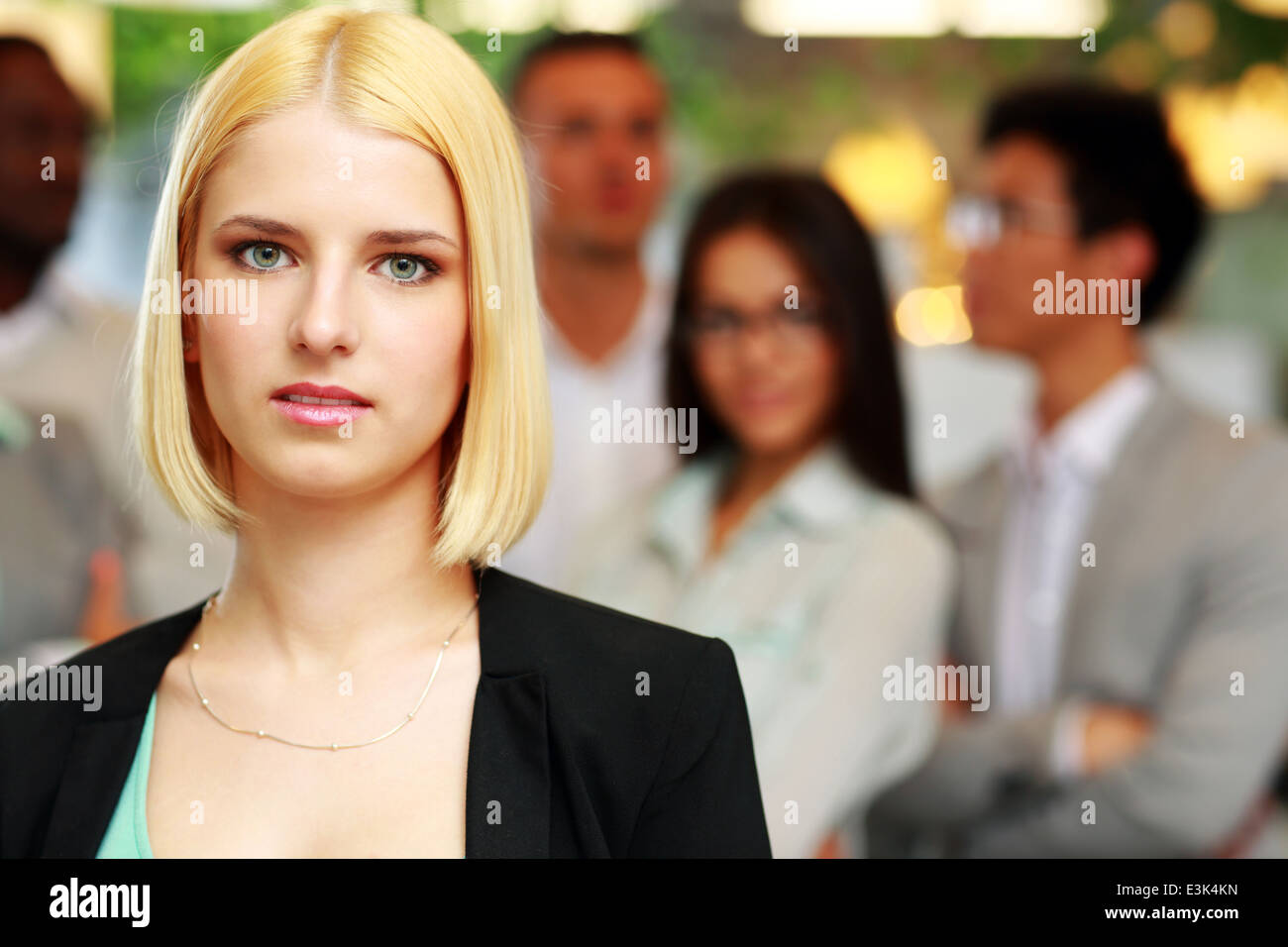 Portrait of a thoughtful businesswoman standing in front of colleagues Stock Photo