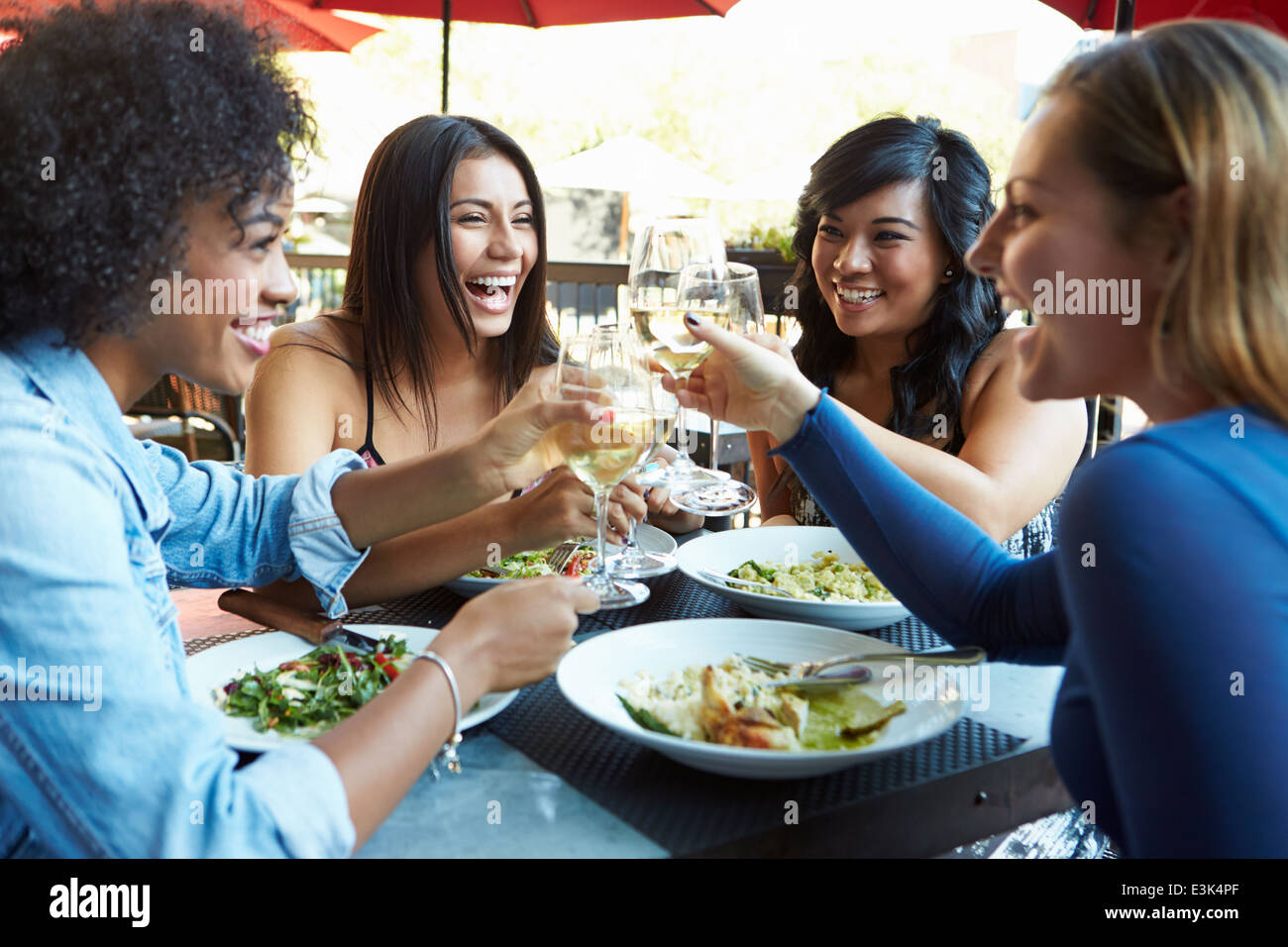 Group Of Female Friends Enjoying Meal At Outdoor Restaurant Stock Photo