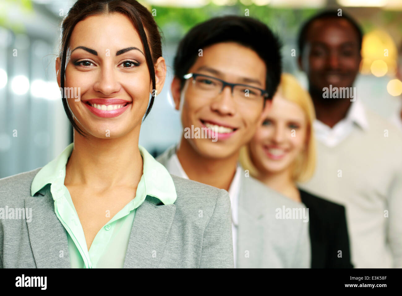 Cheerful businesswoman standing in front of colleagues Stock Photo