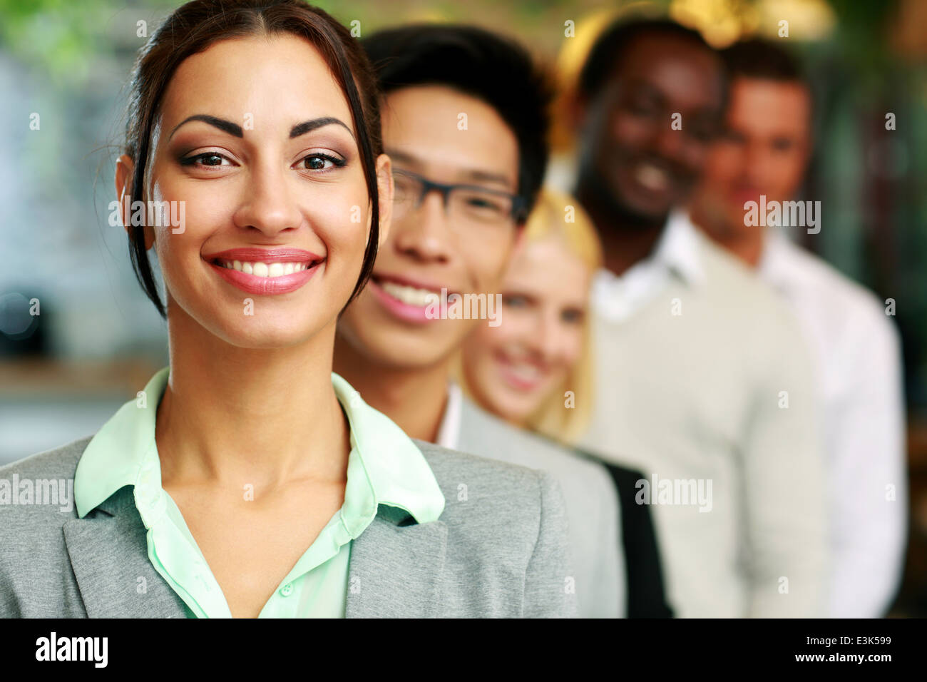Smiling businesswoman standing in front of colleagues Stock Photo