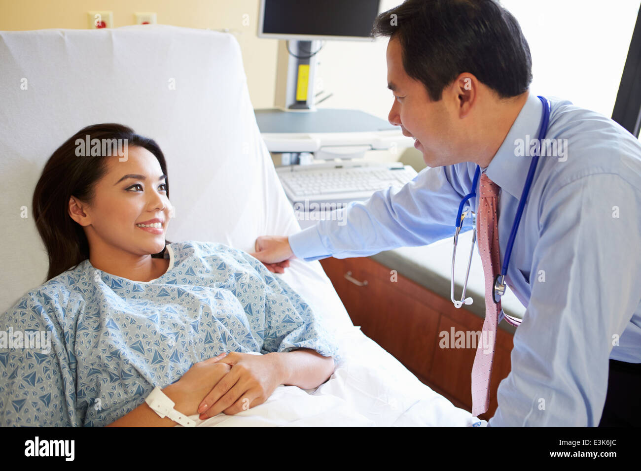 Doctor Talking To Female Patient On Ward Stock Photo