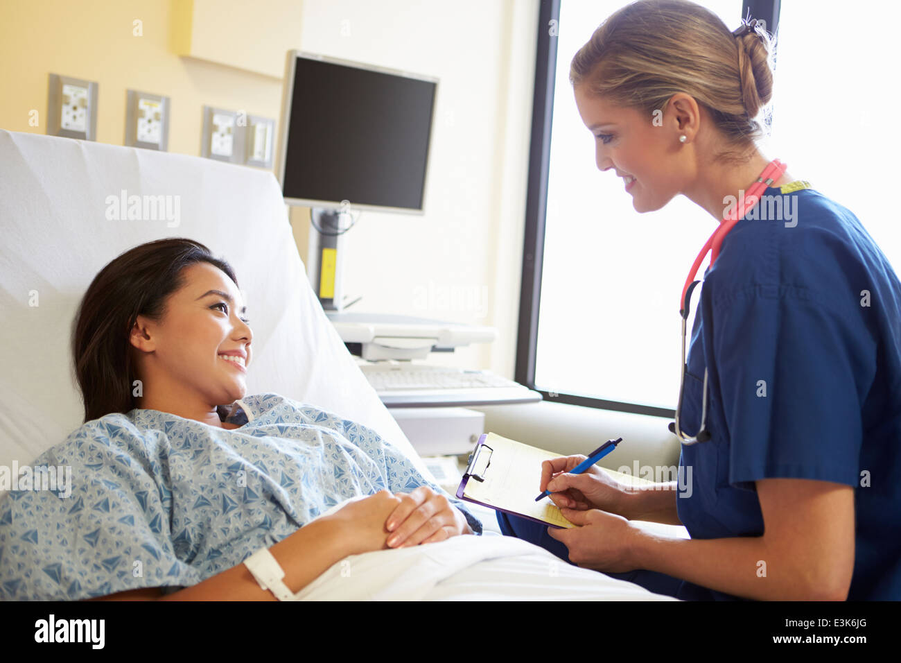 Nurse Talking To Female Patient On Ward Stock Photo - Alamy