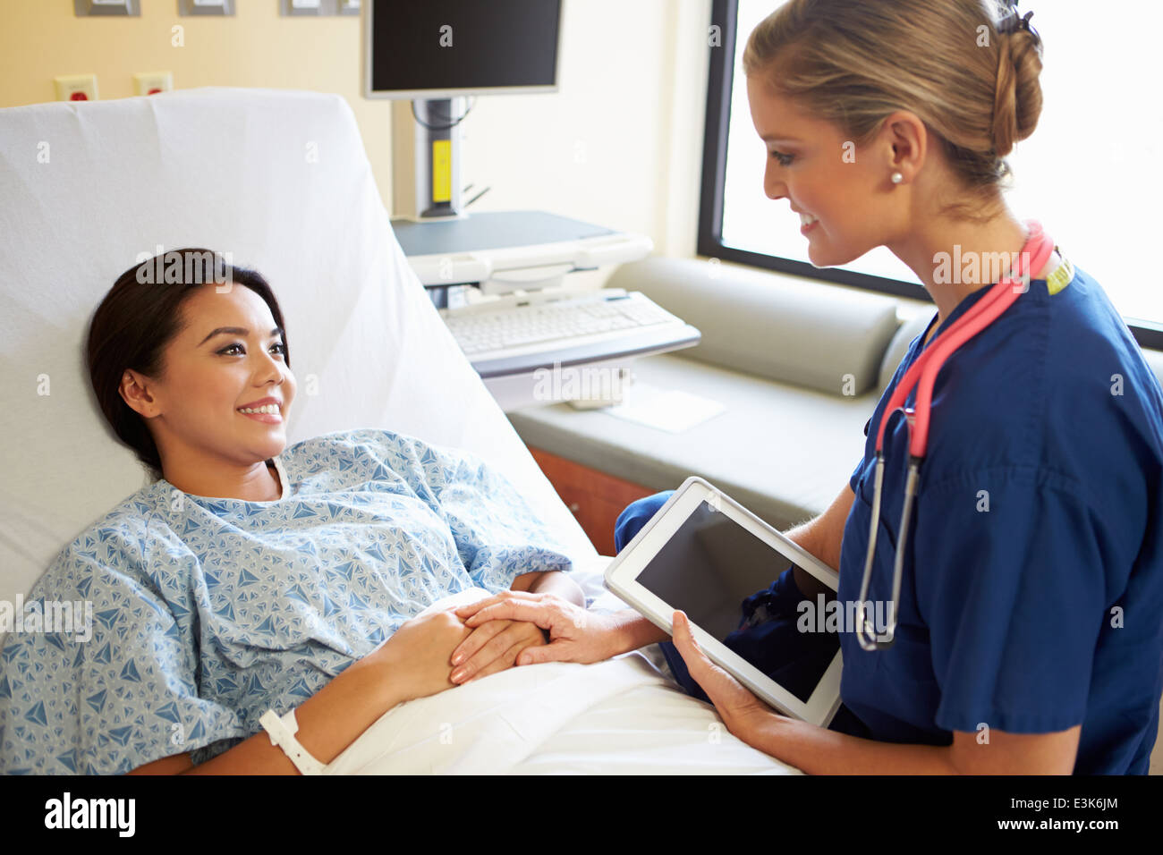 Nurse Talking To Female Patient On Ward Using Digital Tablet Stock ...