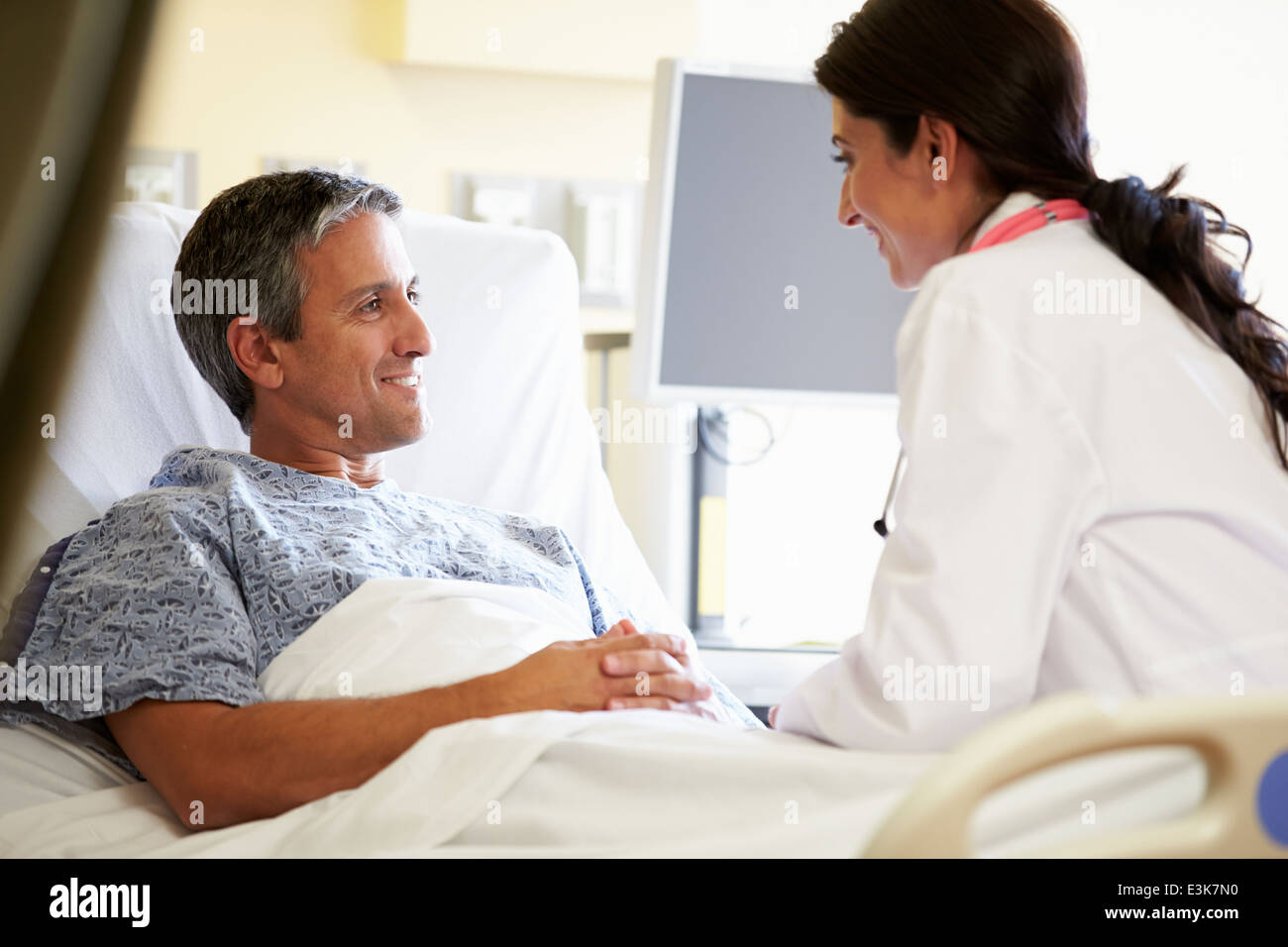Female Doctor Talking To Male Patient In Hospital Room Stock Photo - Alamy