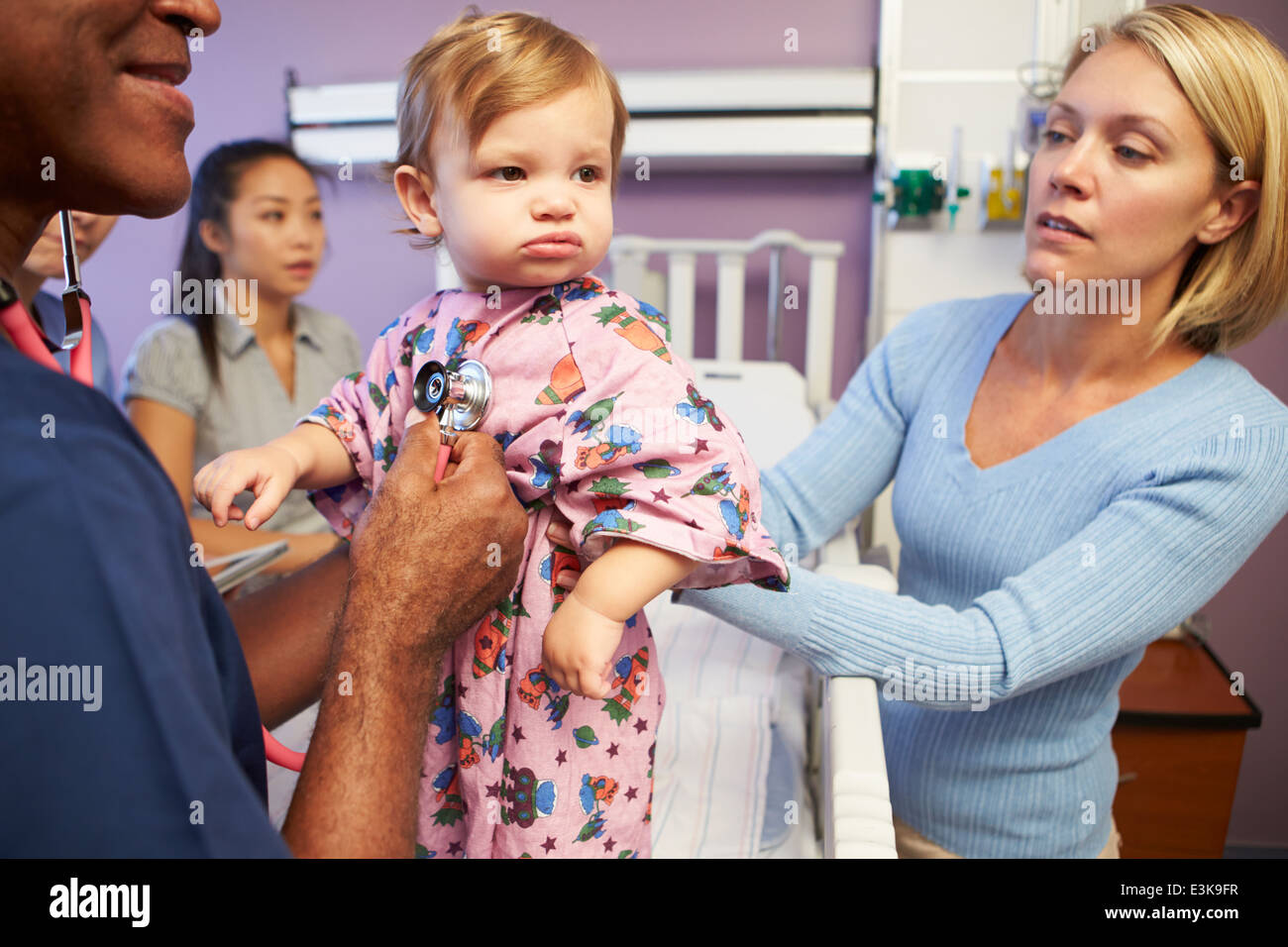 Mother And Daughter With Staff In Pediatric Ward Of Hospital Stock Photo