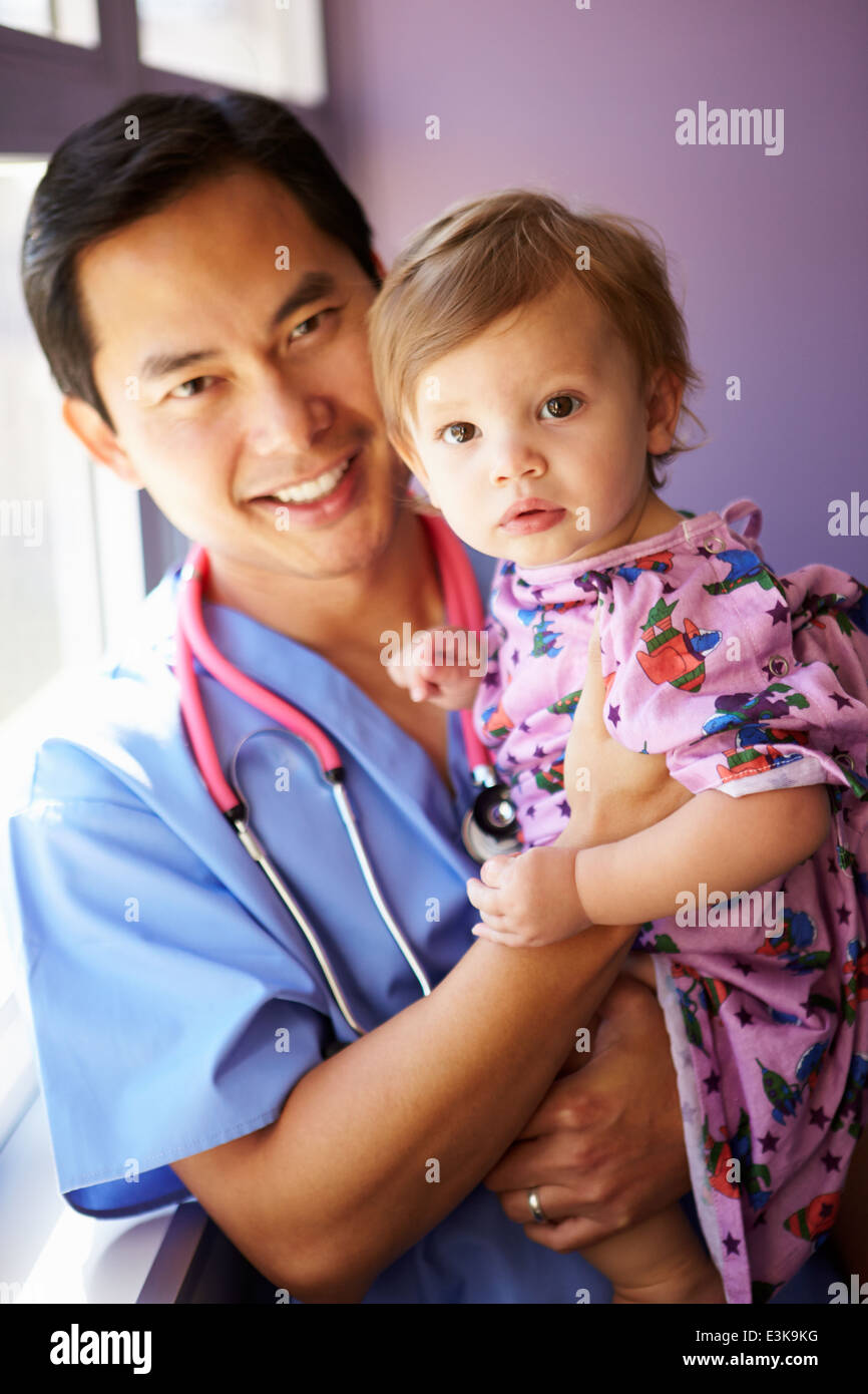 Young Girl Being Held By Male Pediatric Nurse Stock Photo