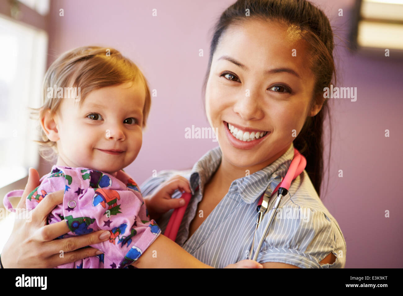 Young Girl Being Held By Female Pediatric Doctor Stock Photo