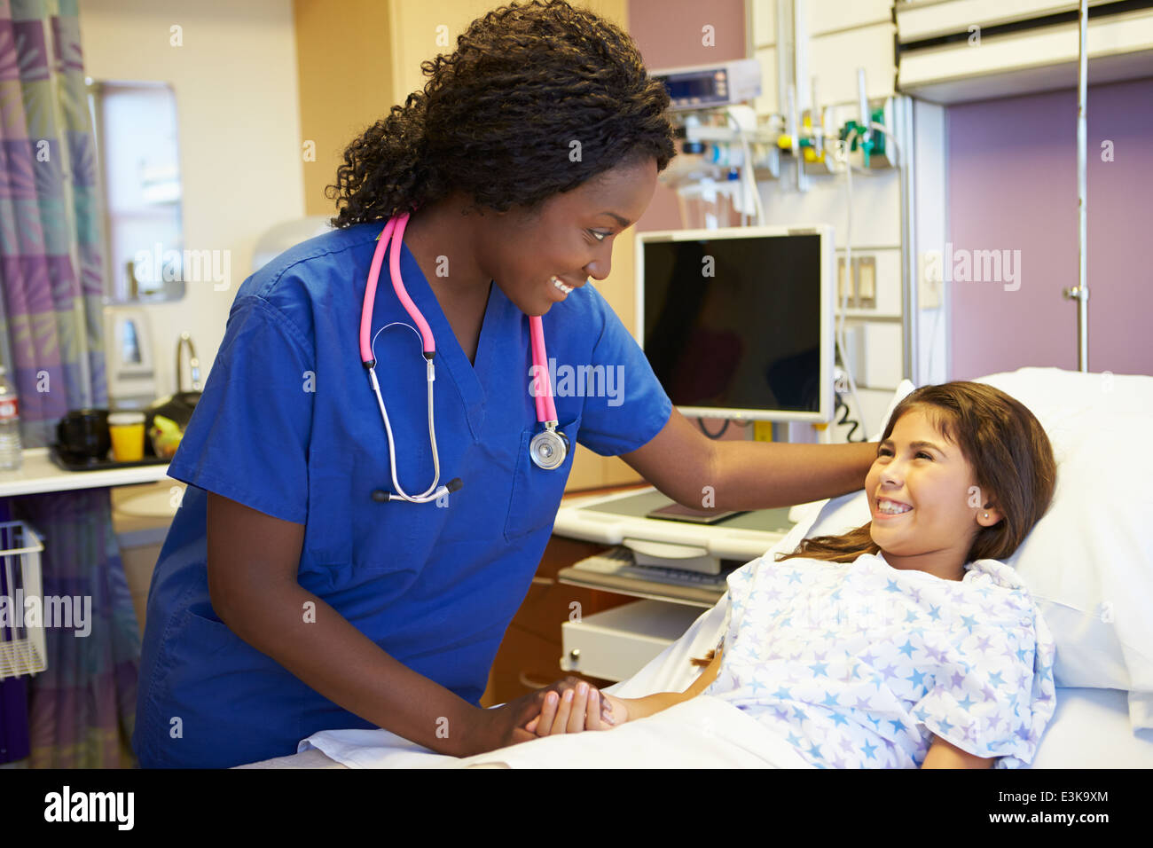 Young Girl Talking To Female Nurse In Hospital Room Stock Photo