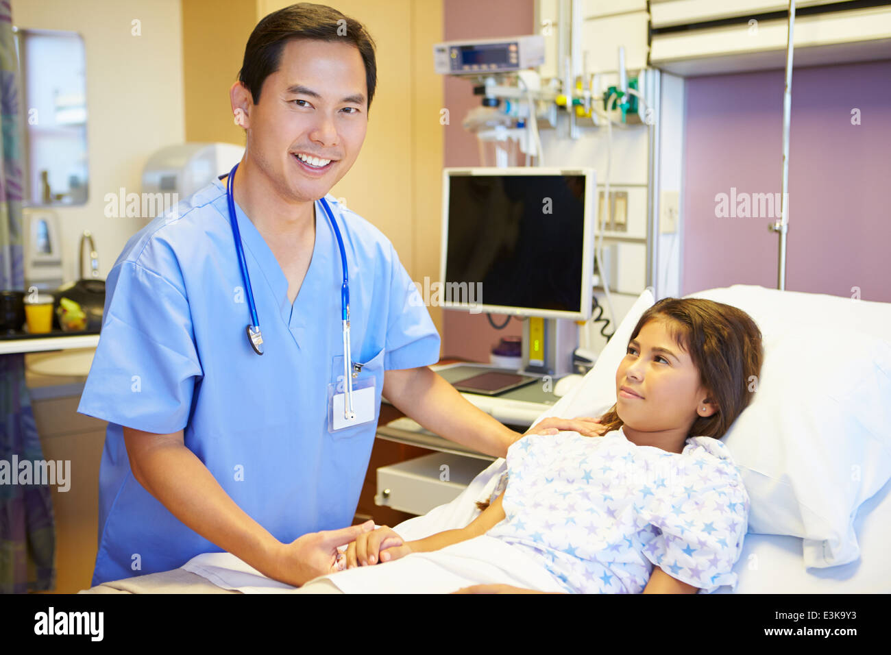 Young Girl Talking To Male Nurse In Hospital Room Stock Photo