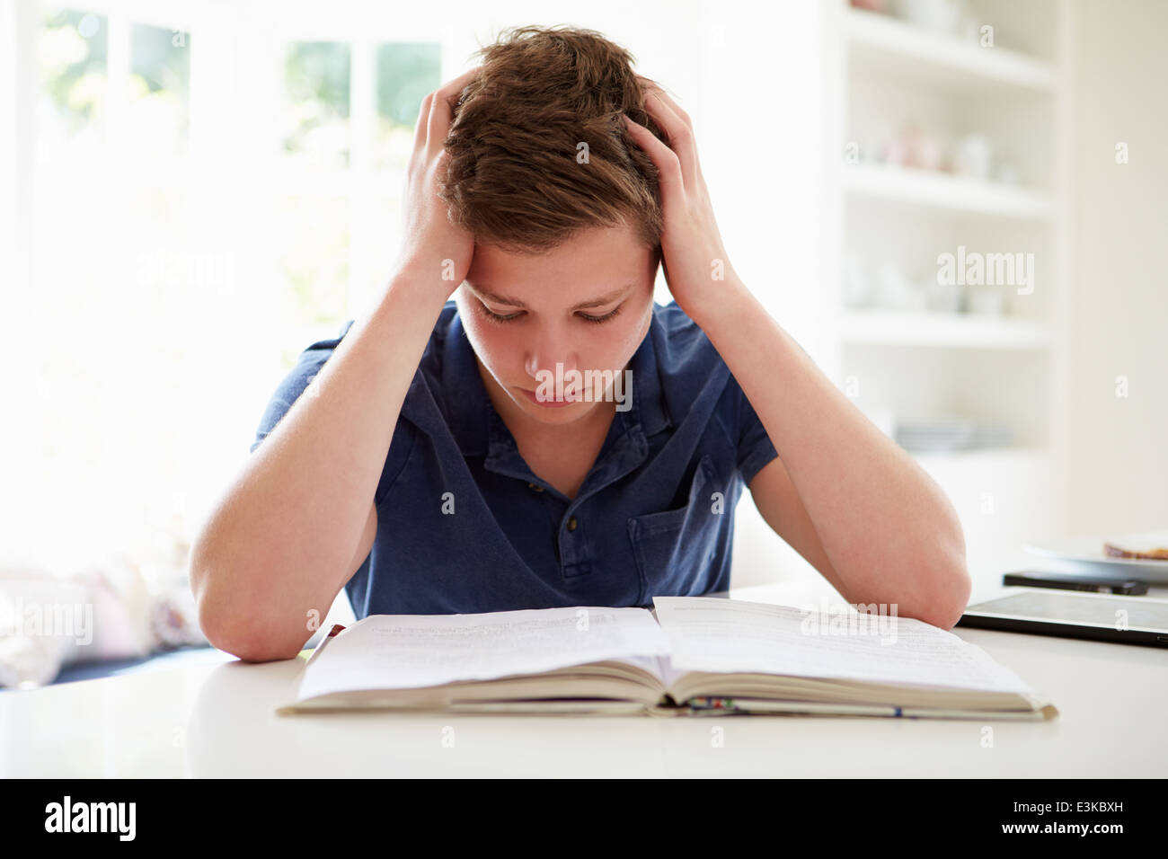 Depressed Boy Studying At Home Stock Photo