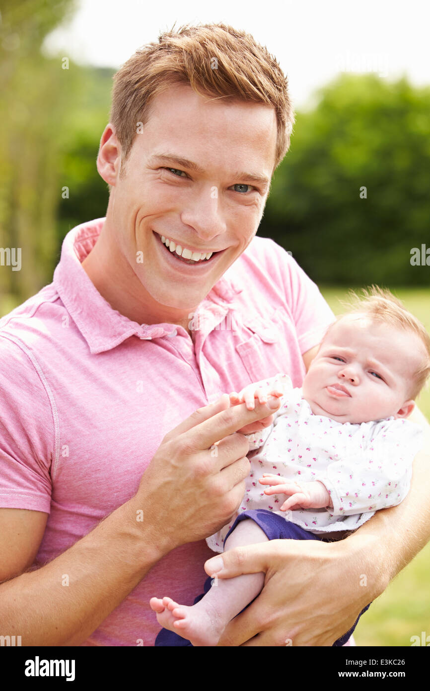 Proud Father Holding Baby Daughter In Garden Stock Photo