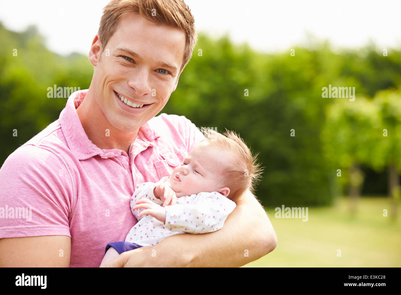 Proud Father Holding Baby Daughter In Garden Stock Photo
