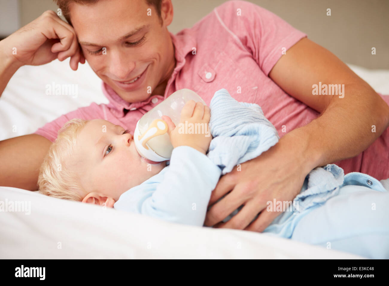 Father Giving Baby Son Bottle Of Milk Stock Photo