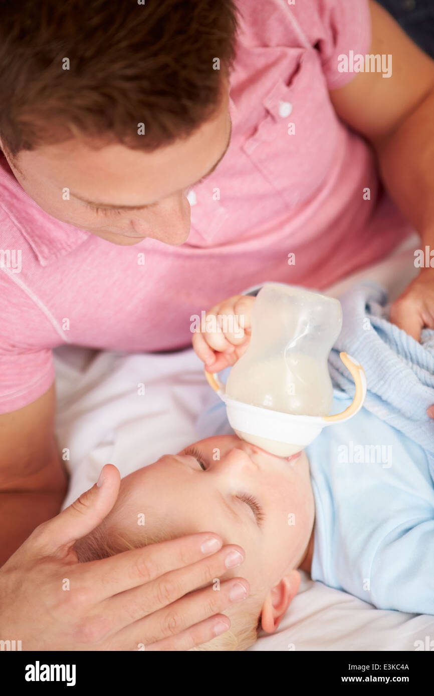 Father Giving Baby Son Bottle Of Milk Stock Photo