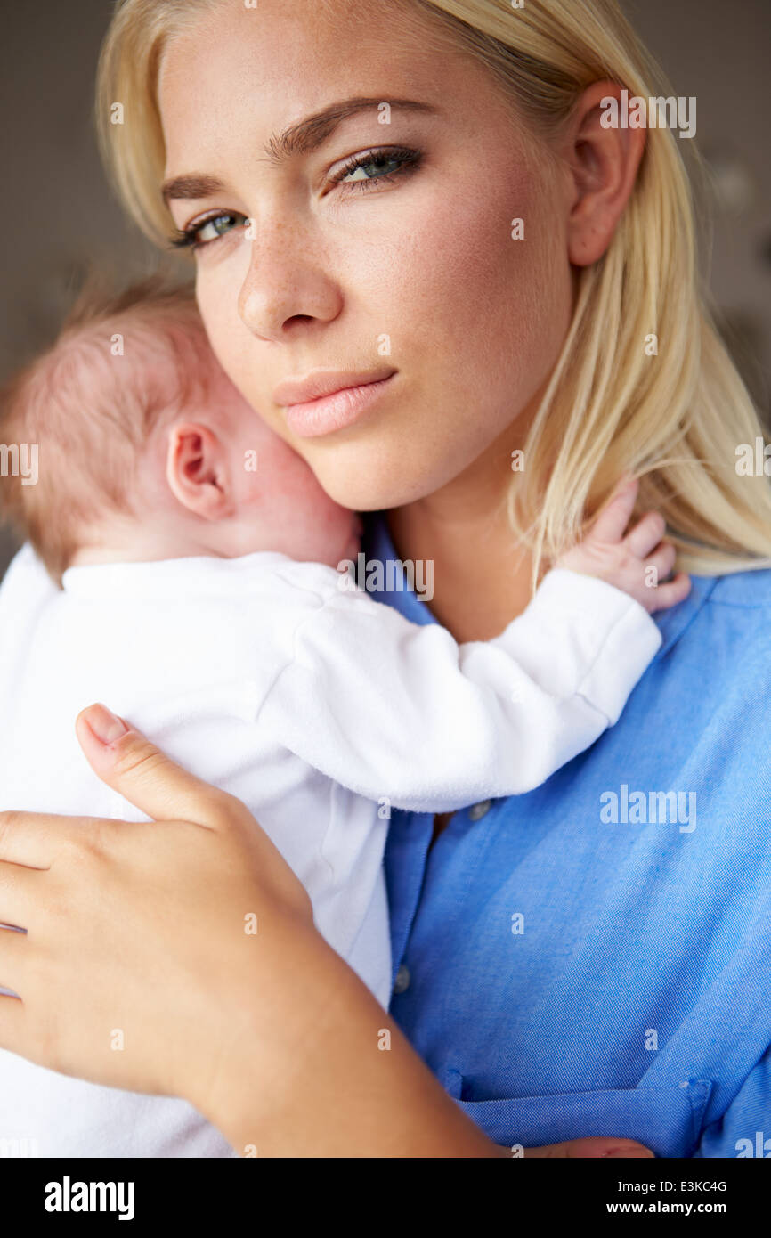 Depressed Mother Cuddling Newborn Baby Stock Photo