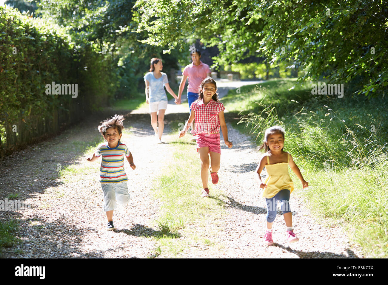 Asian Family Enjoying Walk In Countryside Stock Photo
