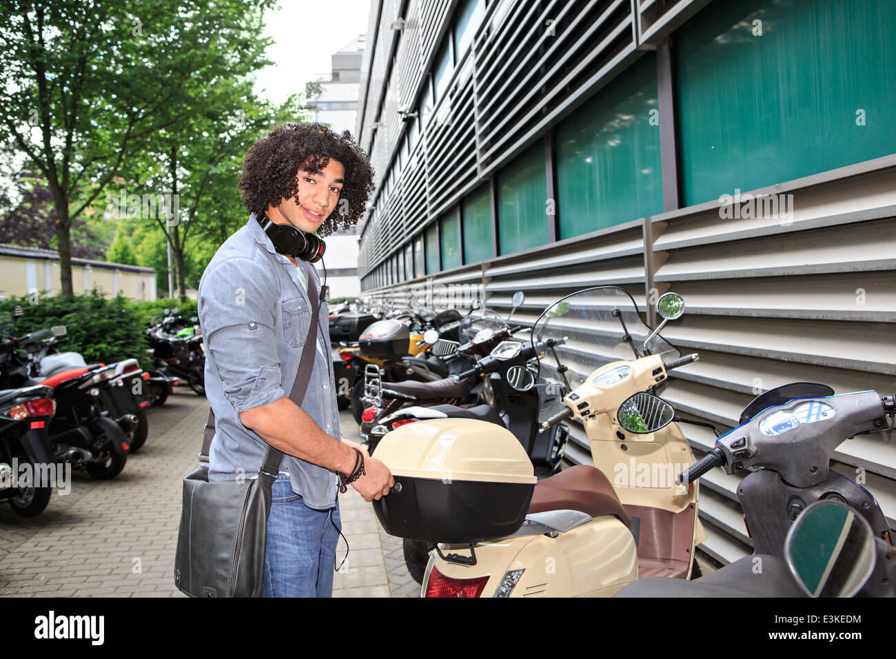 portrait of young male student with a scooter in the town Stock Photo