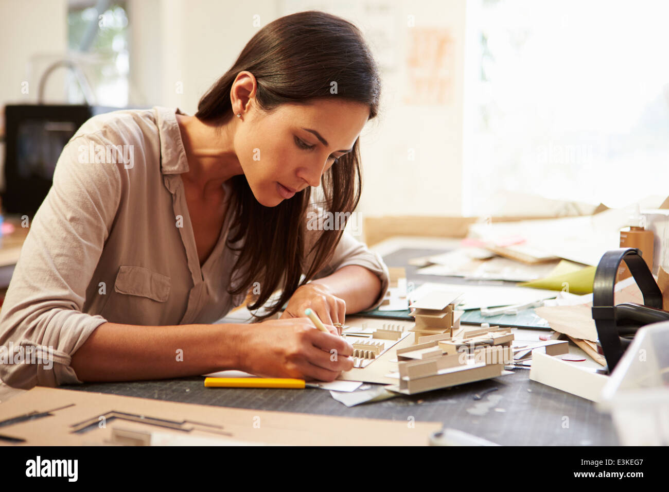 Female Architect Making Model In Office Stock Photo