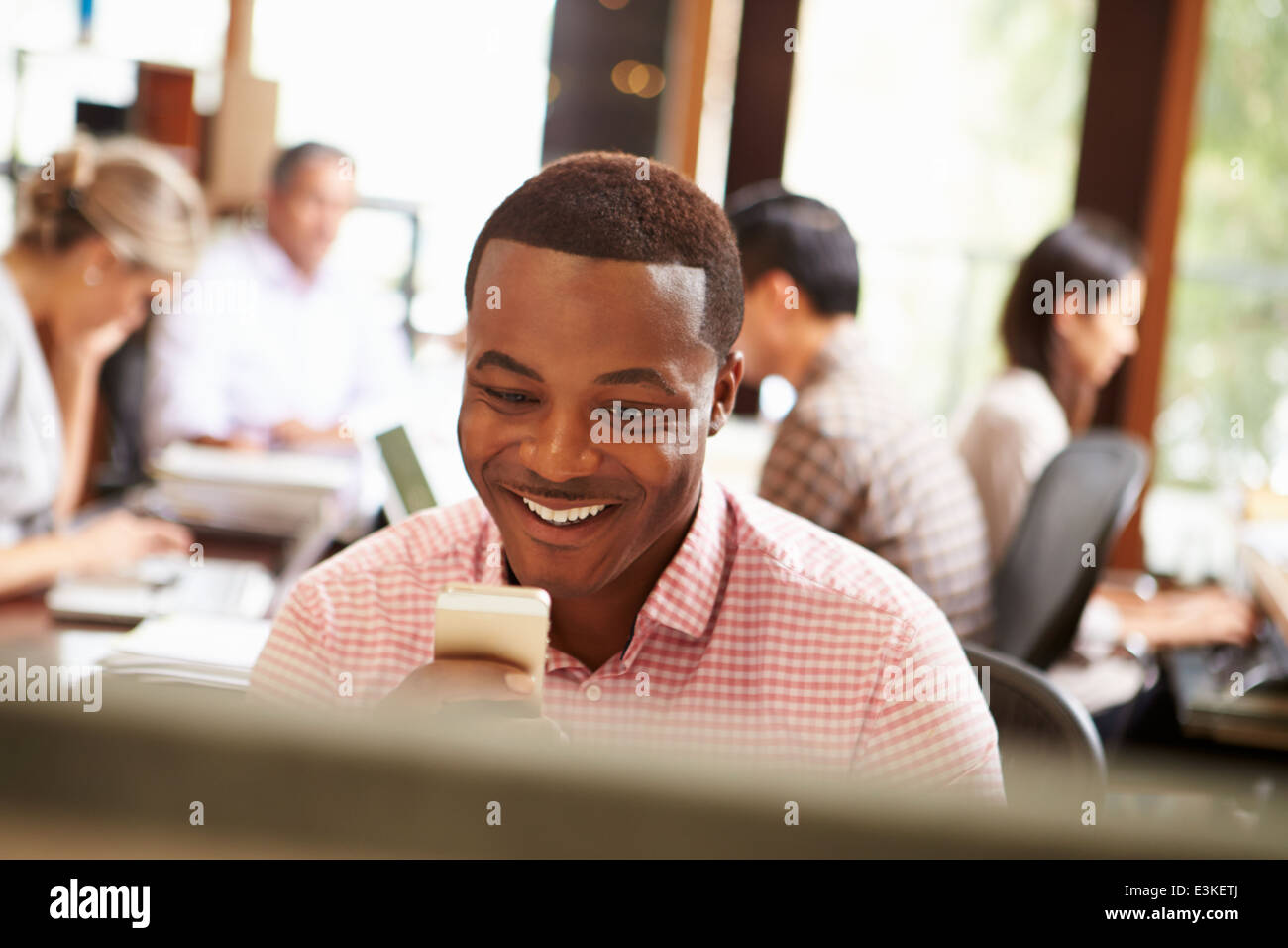 Businessman Working At Desk Using Mobile Phone Stock Photo Alamy