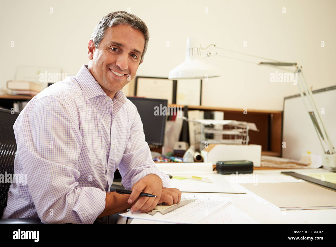 Male Architect Working At Desk In Office Stock Photo