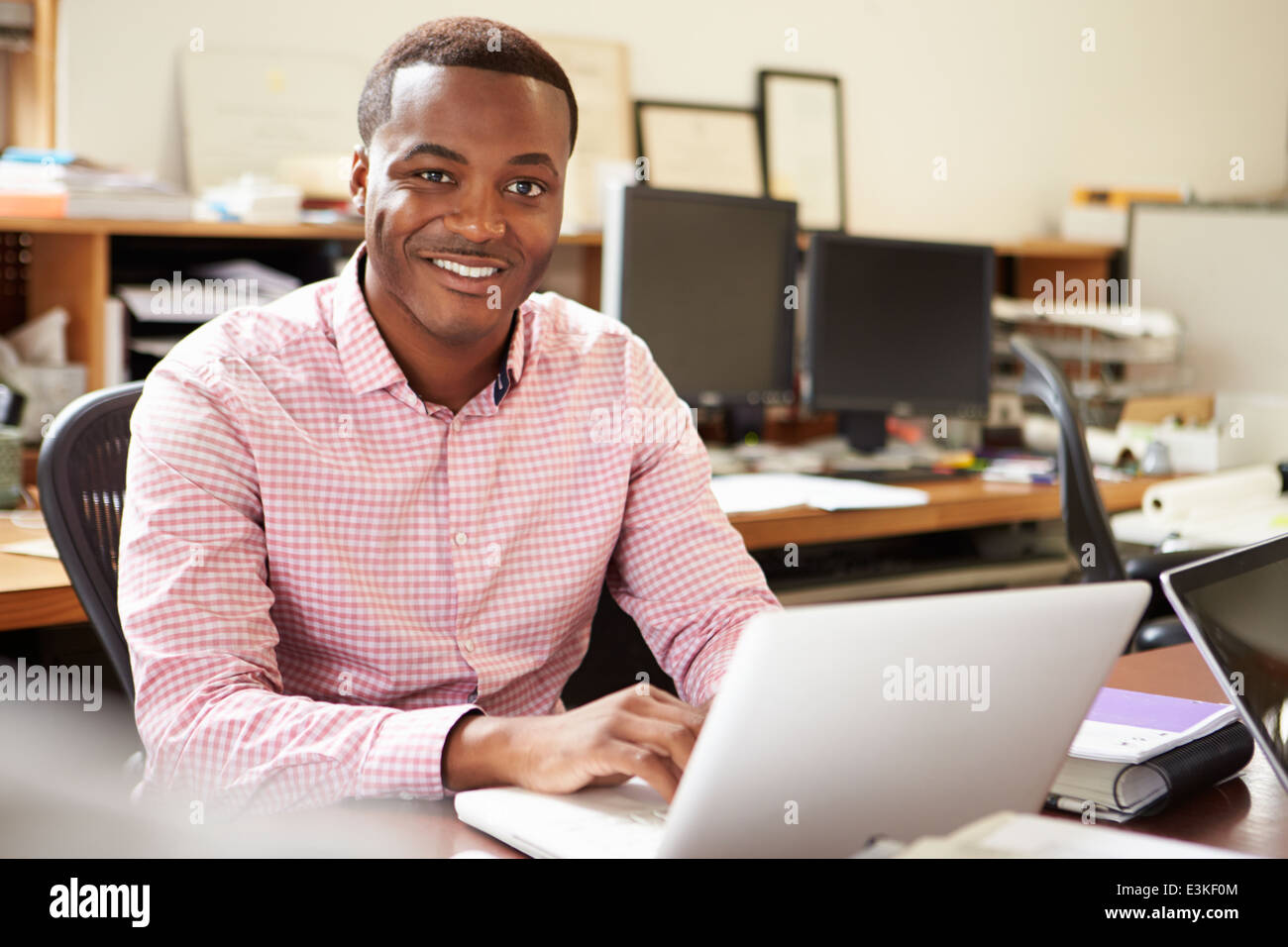 Male Architect Working At Desk On Laptop Stock Photo