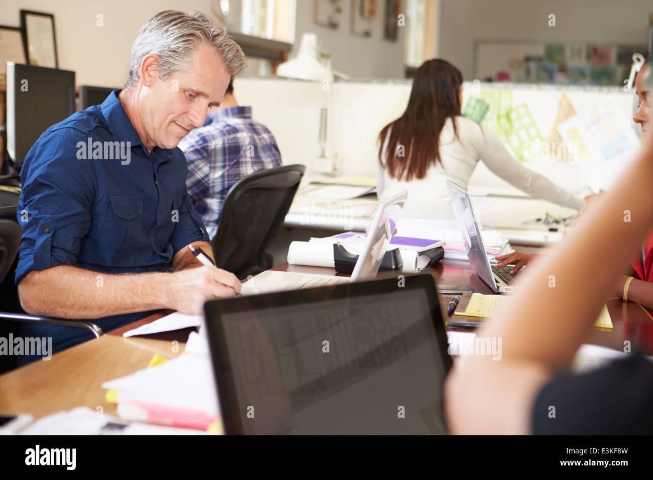 Team Of Architects Working At Desks In Office Stock Photo