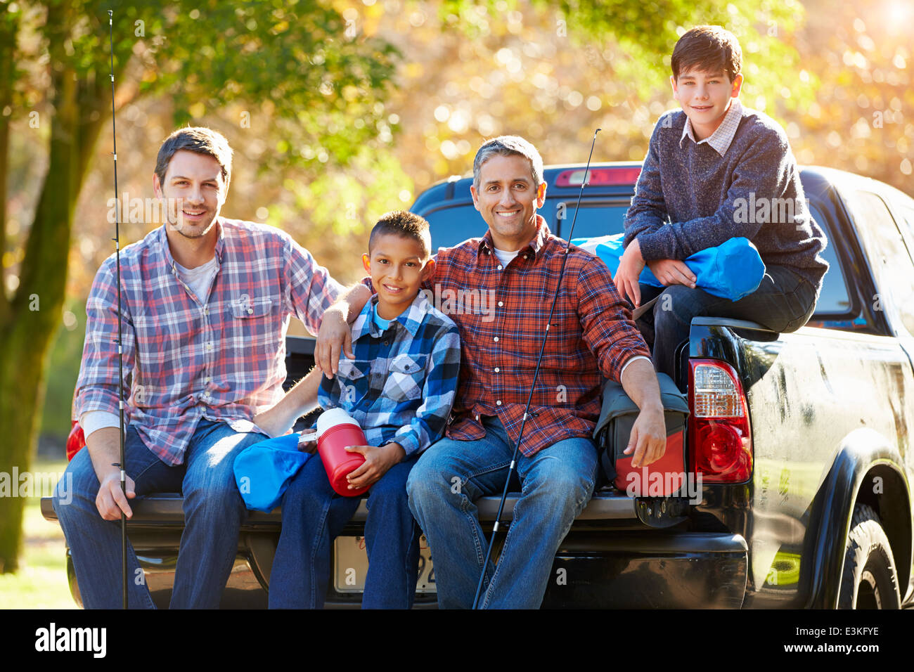 Fathers With Sons Sitting In Truck On Camping Holiday Stock Photo