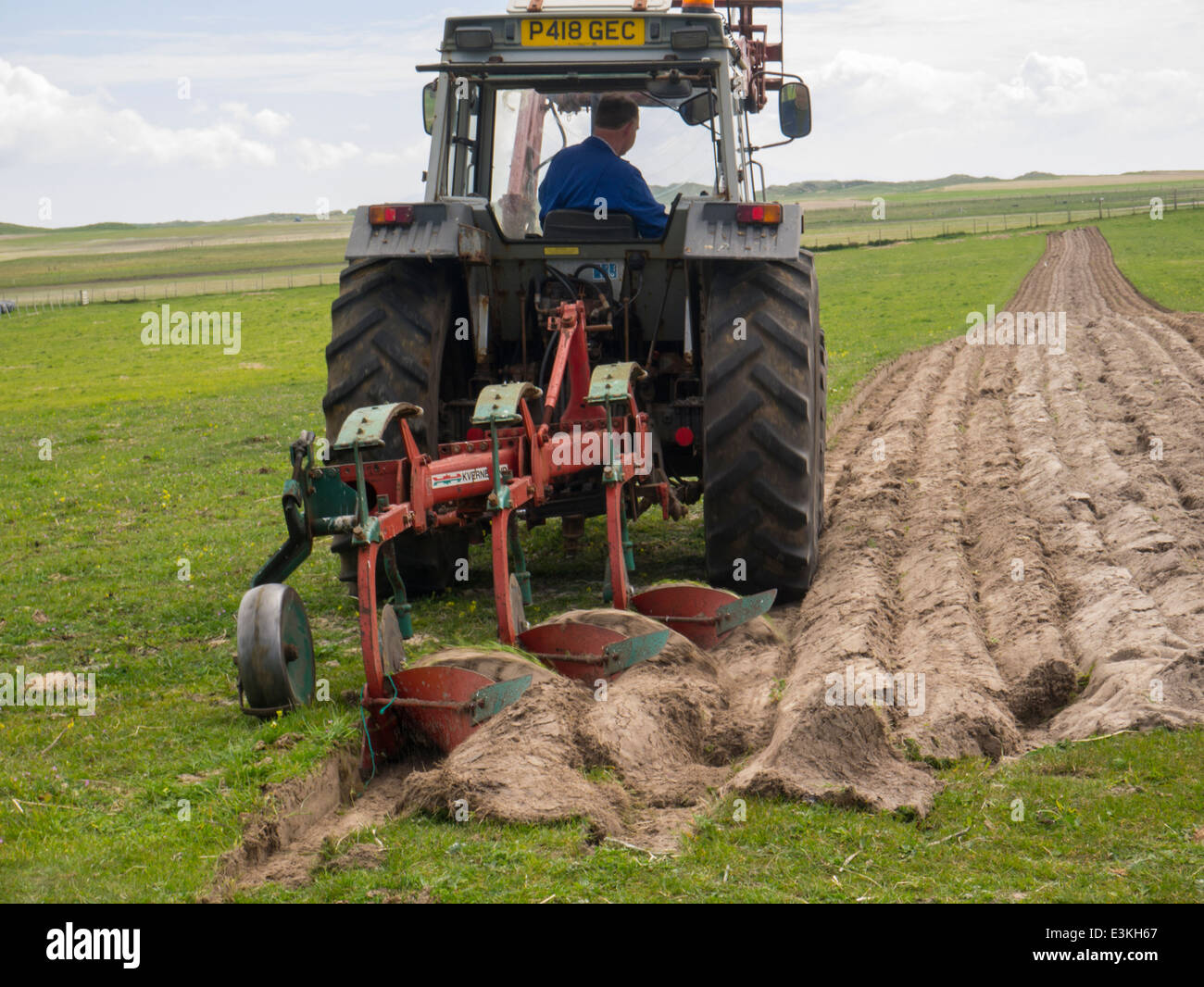 Tractor driver ploughing field on North Uist Outer Hebrides Scottish
