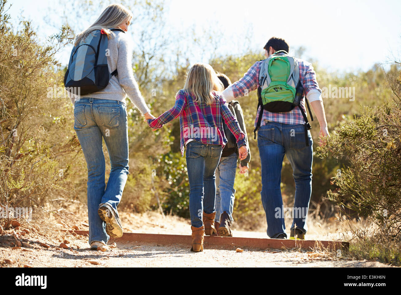 Rear View Of Family Hiking In Countryside Wearing Backpacks Stock Photo