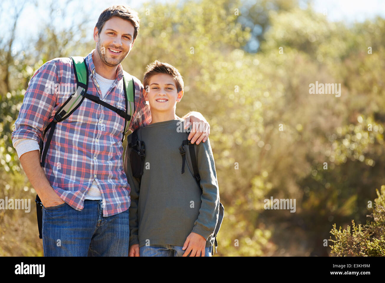 Father And Son Hiking In Countryside Wearing Backpacks Stock Photo