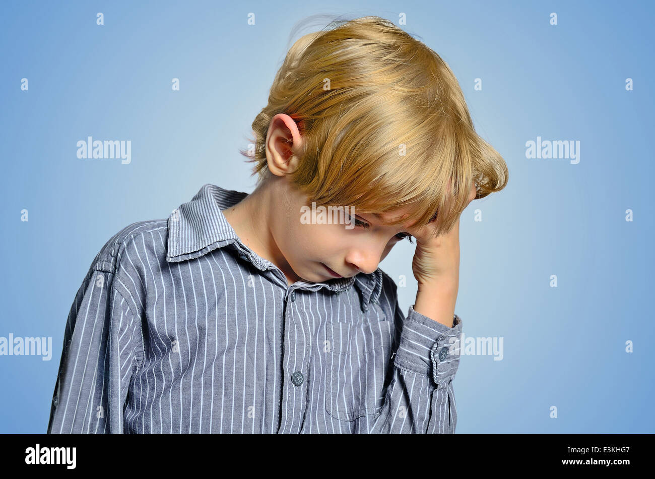 Young depressed boy on blue background Stock Photo
