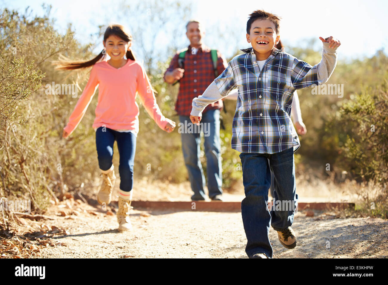 Father And Children Hiking In Countryside Wearing Backpacks Stock Photo